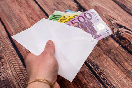 Different euro in a white envelope on the table.
