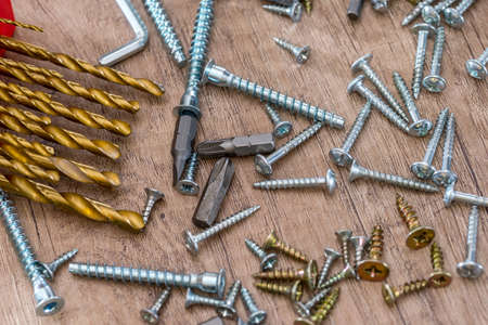 different drill and screws on wooden desk.の写真素材