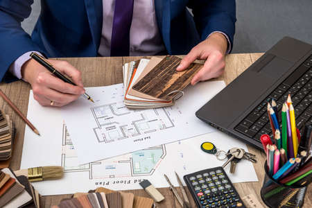male designer at office with wooden color swatches, house projectの写真素材