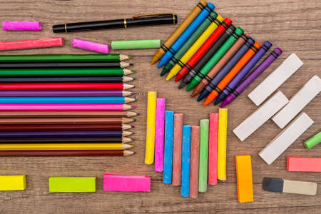 School Supplies - colored chalks and pencils on a wooden background.の写真素材