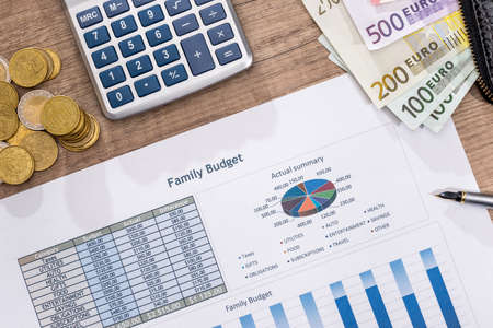 Business financial reports with euros bills, coin and calculator.