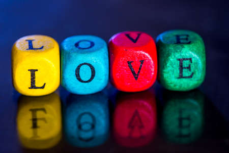 Word "love" of the colored wooden cubes isolated on dark background.の写真素材