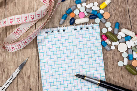 fitness concept of weight loss - notepad, pills, meter, calculator.の写真素材