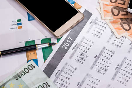 business concept - euros bills, calendar, pen and calculator.