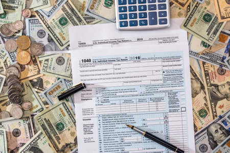 closeup of us tax form and us money with calculator, coin.の写真素材