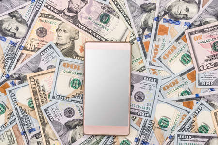 Mobile smartphone and dollar banknote. close up