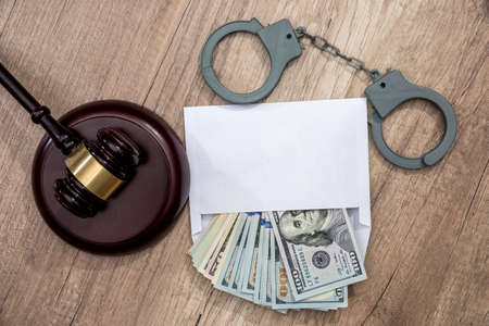 The concept of corruption - dollars in an envelope, handcuffs and hammer judges