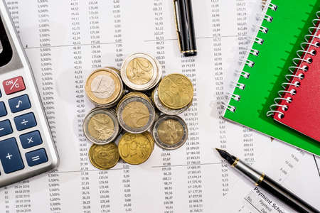 notepad, financial documents, calculator, pen and coin