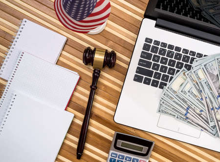 gavel with laptop, dollar, notepad and flag