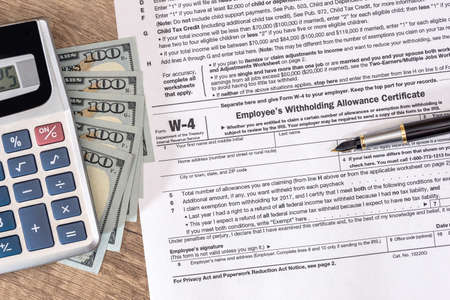 w4 tax form with money and pen.