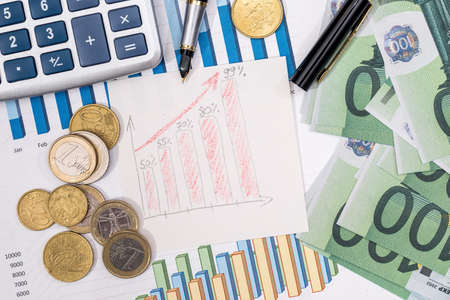 Stock market prices chart with euro bills and coin, pen.の写真素材