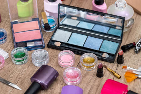 makeup cosmetics and manicure tools on a wooden background.