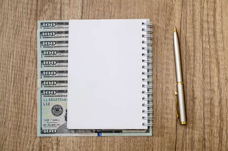 american hundred dollar and pen and empty note on deskの写真素材