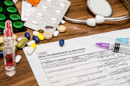 Doctor's stethoscope with patient form and bottle of pills on the desk