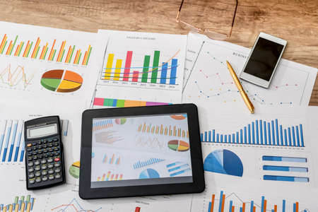 business workplace with digital tablet, mobile smartphone and some charts and graphs, penの写真素材