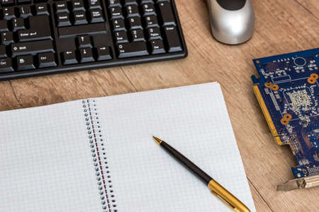 motherboart, blank paper, pen and keyboard on desk