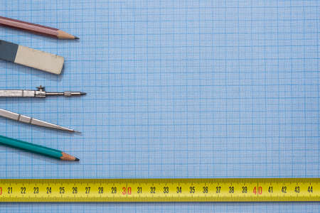 drawing compass, pencil, and ruler on graph paper backgroundの写真素材