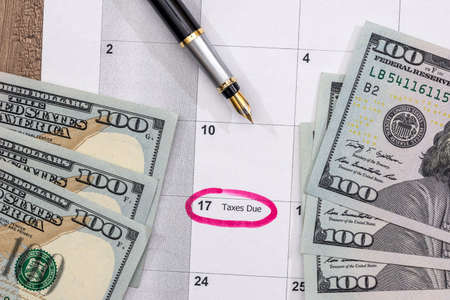 Dollars on the calendar - april 2017 with pen on desk.
