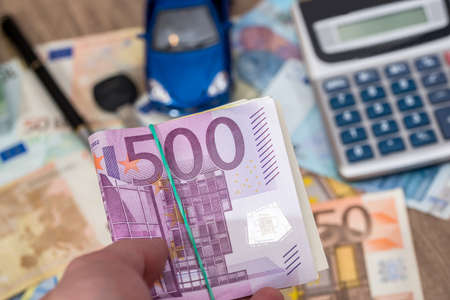 blue toy car with euro banknotes, calculator and pen.の写真素材