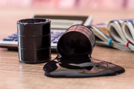 black barrel with oil lies on dollar banknotes with calculator on desk. Sale of oil. Oilの写真素材