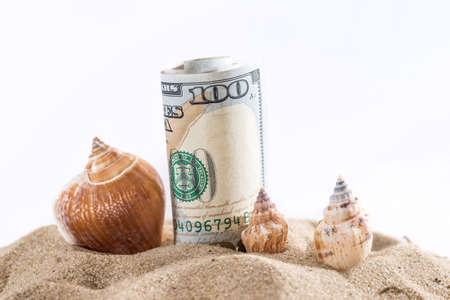 dollar in sand with shell isolated on white. summer conceptの写真素材