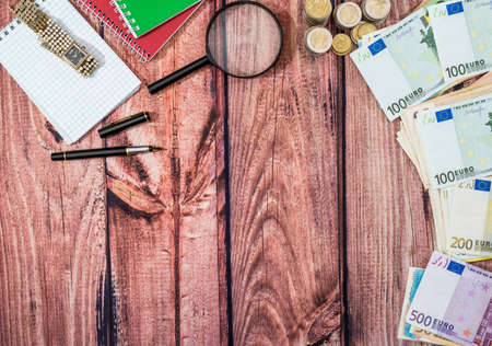 opne notepad, pen, calculator with euro coin and banknotes on desk.の写真素材