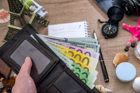 travel concept - old camera, empty notebook with pencil, euro bills, compass, seashell, phone.の写真素材