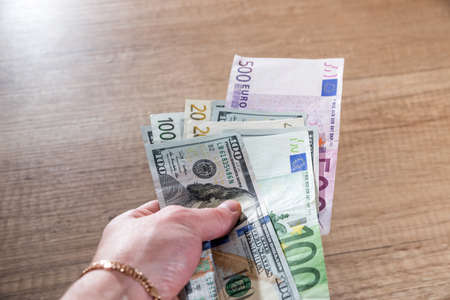 Woman holding euro and dollar bills. money concept.の写真素材
