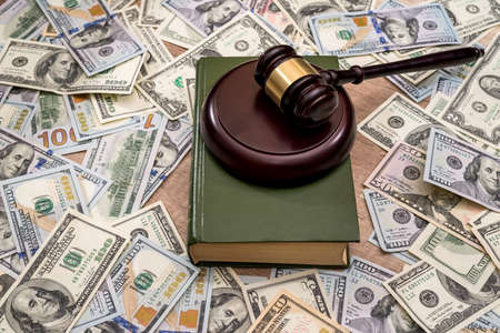 wooden hammer judge against the background of dollarsの写真素材