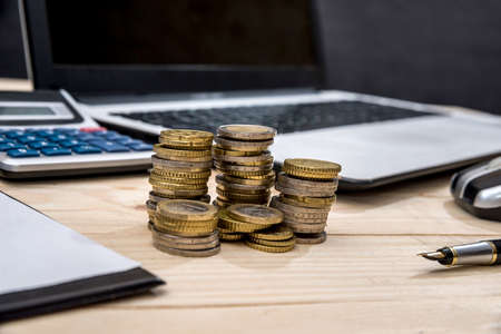 laptop with coin and business graph on tableの写真素材