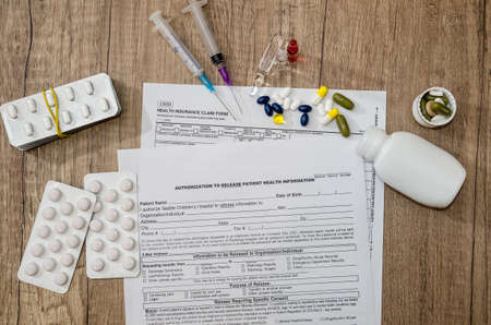 Prescription form lying on table with pills and syringesの写真素材