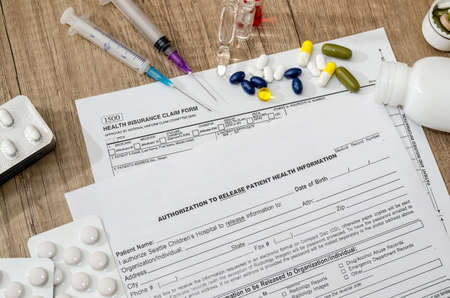 Medical patient form with pills and syringes on table