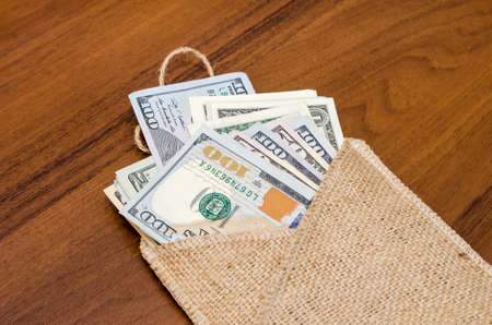 Dollars of different values in sack on tableの写真素材