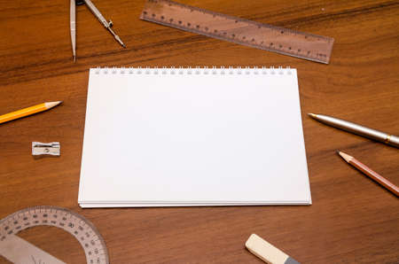 Office workplace - empty notepad, pen, pencil, ruler, compass on dark wooden background