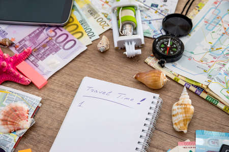 Summer holiday background - notebook with selfie stick, money, glasses, map, seashells, compass.の写真素材