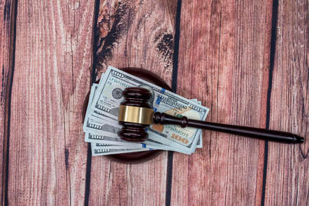 Us Money with judges hammer on wooden table, top view.