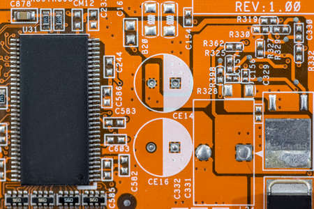 old orange motherboard as background. electronic components.