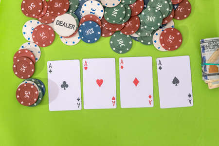 Poker chips and play card with dollar on green
