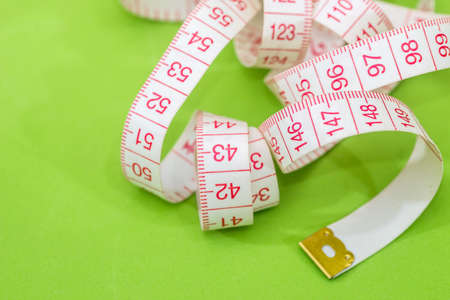 Measuring tape of the tailor isolated on greenの写真素材