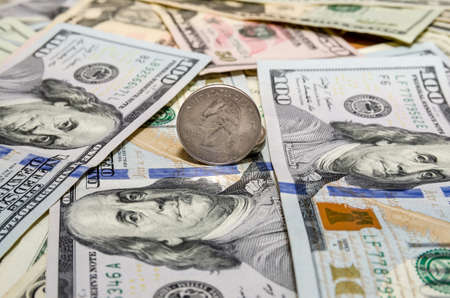 Quarter dollar coin and One Hundred Dollar banknotes currency of the United States