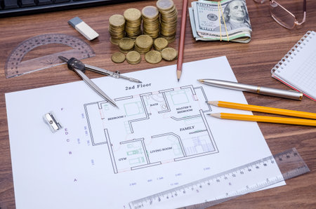 drawing house with coin, pen and pencil on table