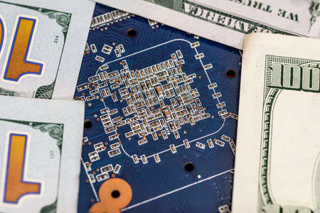 Closeup of one hundred dollar with blue computer motherboardの写真素材
