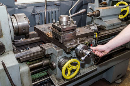 workmen working on industrial lathe