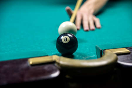 man playing billiards in dark club