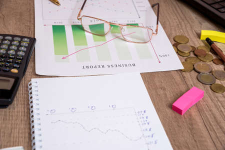 analyzing investment graphs with laptop and calculator