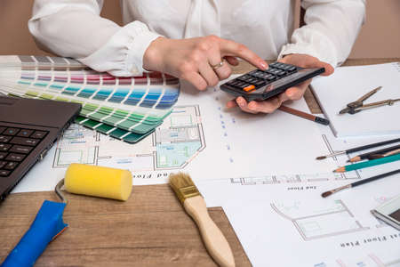 Professional worker drawing on house project with work tools