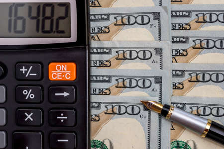 calculator and pen on dollar billsの写真素材