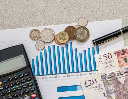 pound on fluctuating graph with calculator and penの写真素材