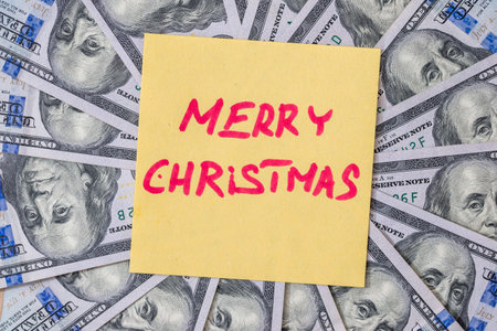 Merry Christmas text on a background of dollarsの写真素材