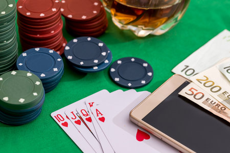 Poker chips, cards and euro bills with cognac glass